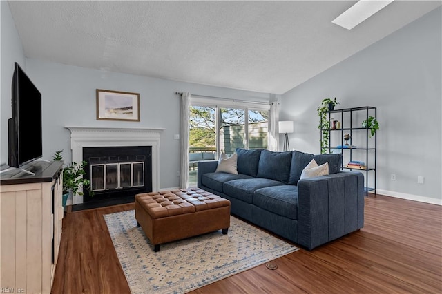 living room featuring lofted ceiling with skylight and dark hardwood / wood-style flooring