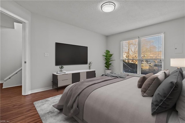 bedroom with dark wood-type flooring and a textured ceiling