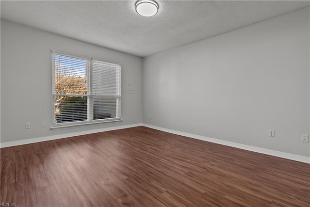 empty room featuring wood-type flooring and a textured ceiling