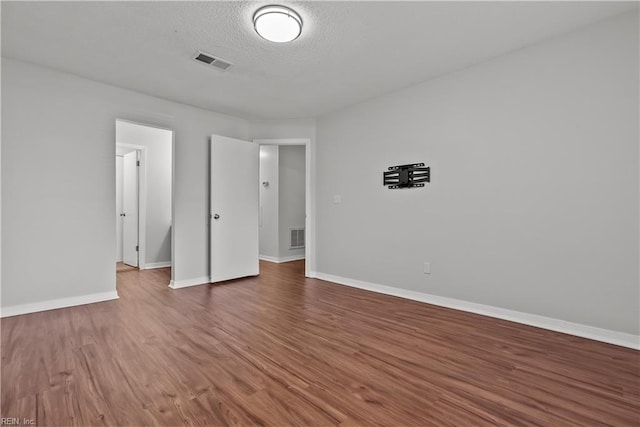 unfurnished bedroom with dark wood-type flooring and a textured ceiling