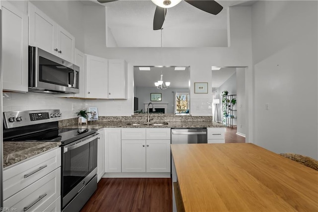 kitchen featuring stainless steel appliances, decorative light fixtures, sink, and white cabinets