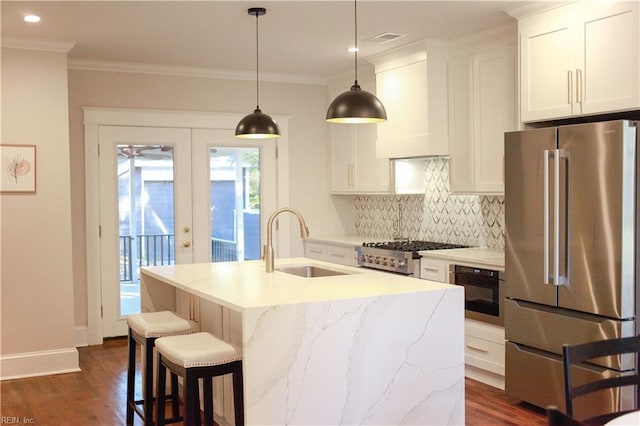 kitchen with sink, appliances with stainless steel finishes, an island with sink, white cabinets, and custom exhaust hood