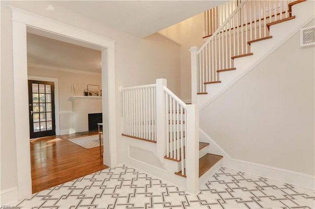 stairway with crown molding and hardwood / wood-style flooring