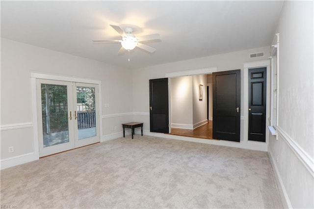 unfurnished room featuring light carpet, french doors, and ceiling fan