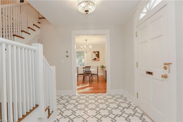 entrance foyer featuring an inviting chandelier, ornamental molding, and a healthy amount of sunlight