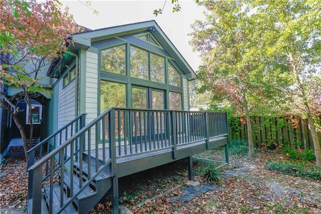 rear view of property featuring a wooden deck and a sunroom