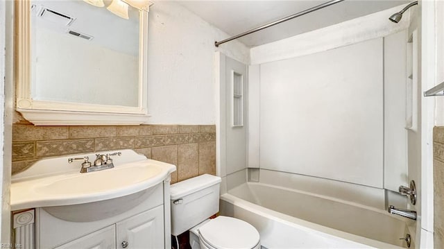 full bathroom with vanity, tile walls, shower / bathtub combination, and toilet