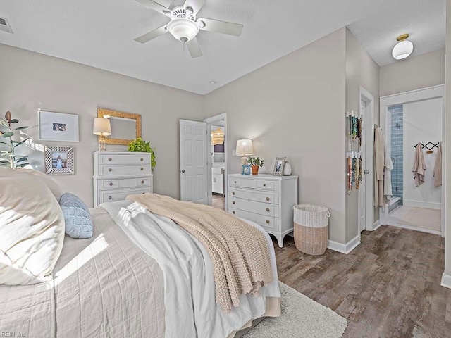 bedroom featuring connected bathroom, ceiling fan, and dark hardwood / wood-style flooring