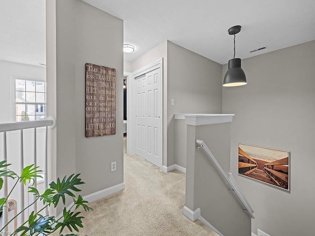 hallway with light colored carpet