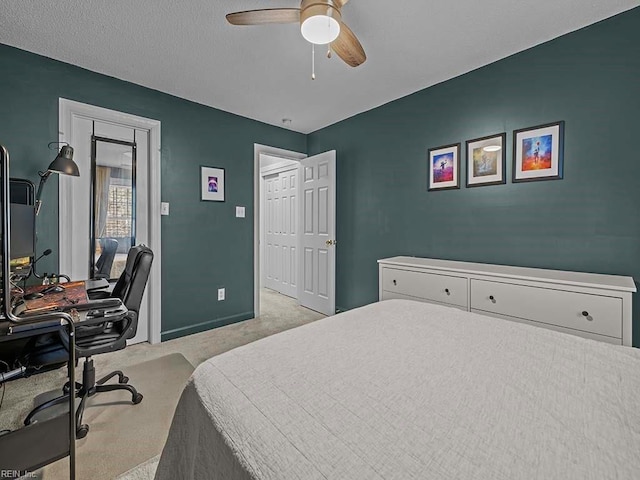 carpeted bedroom featuring ceiling fan and a textured ceiling