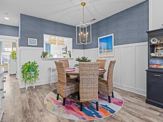 dining space with hardwood / wood-style flooring and an inviting chandelier