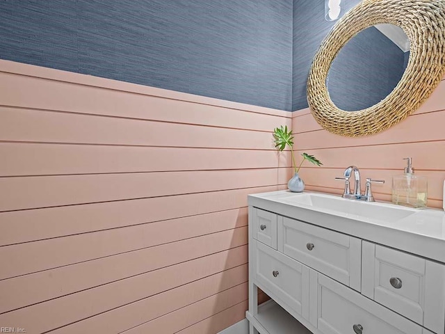 bathroom featuring vanity and wood walls