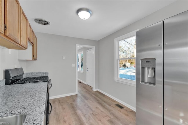 kitchen with sink, light brown cabinets, light wood-type flooring, and appliances with stainless steel finishes