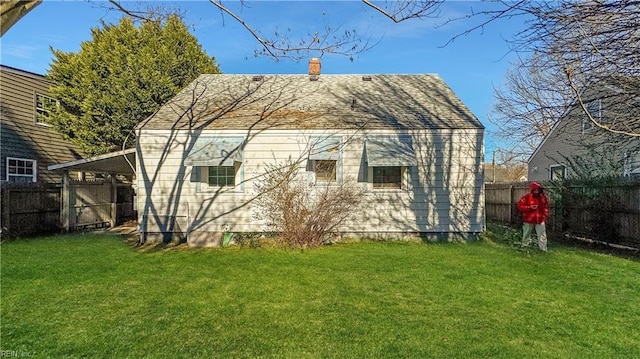 rear view of property featuring a lawn