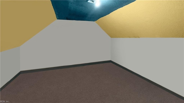 additional living space featuring lofted ceiling and carpet flooring