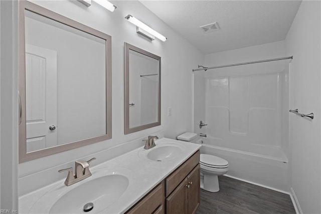 full bathroom with vanity, hardwood / wood-style flooring, shower / washtub combination, and toilet