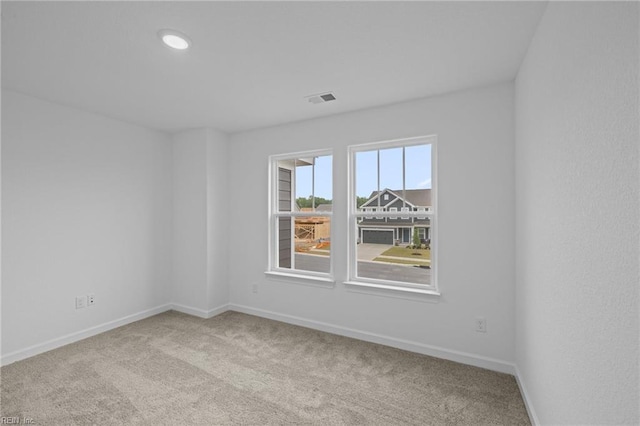 unfurnished room featuring light carpet