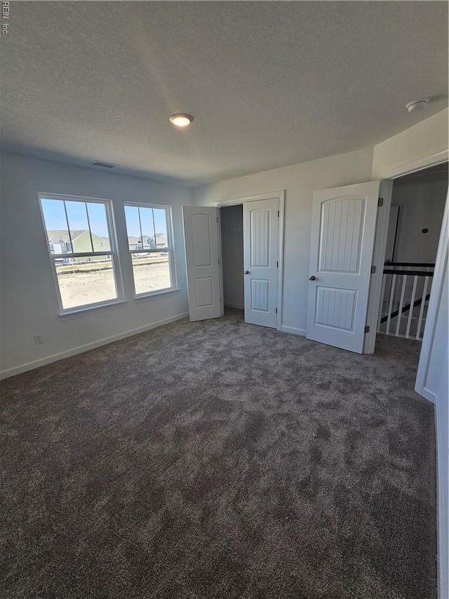307 Iris Cir, Moyock, NC 27958 - unfurnished bedroom with carpet, baseboards, a textured ceiling, and a closet