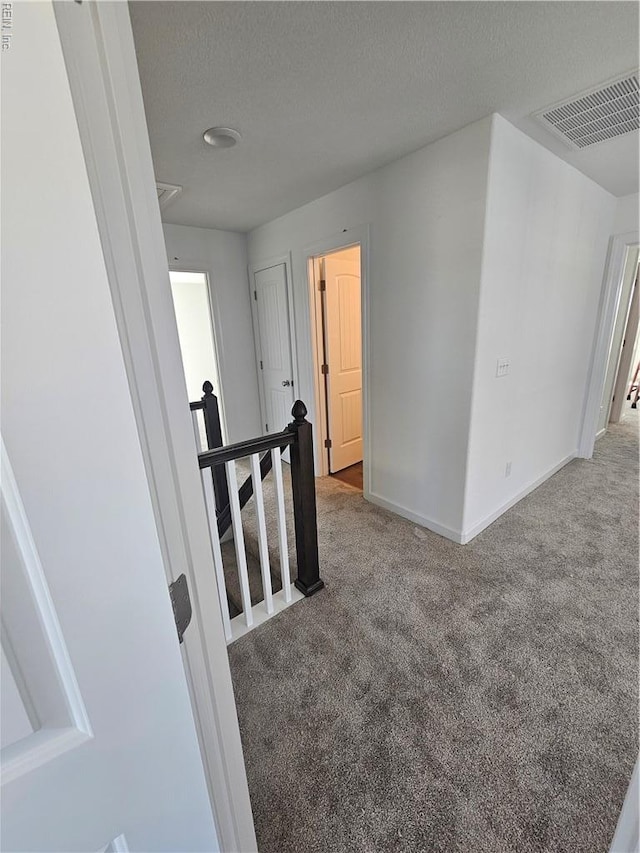 307 Iris Cir, Moyock, NC 27958 - corridor featuring an upstairs landing, carpet flooring, baseboards, a textured ceiling, and attic access