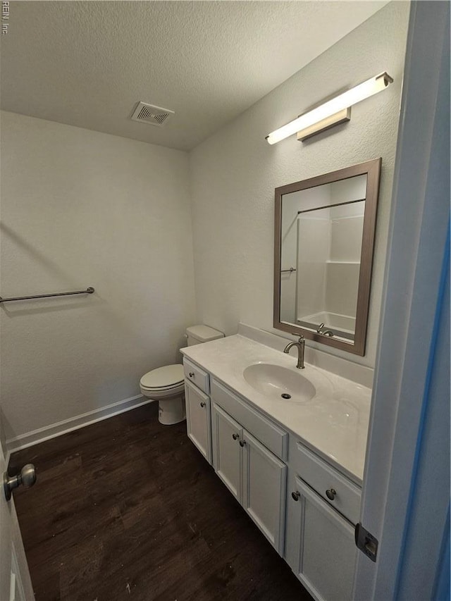 307 Iris Cir, Moyock, NC 27958 - bathroom featuring wood finished floors, vanity, toilet, a textured ceiling, and baseboards