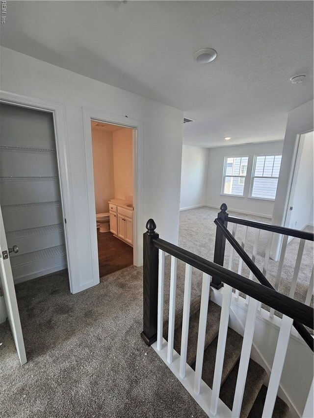 307 Iris Cir, Moyock, NC 27958 - hallway featuring dark carpet, an upstairs landing, and baseboards