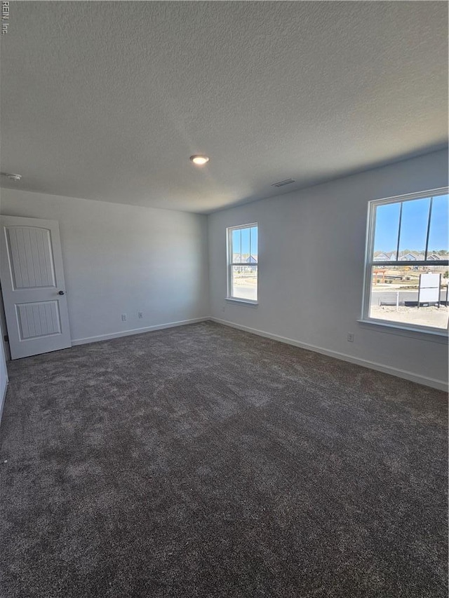 307 Iris Cir, Moyock, NC 27958 - empty room featuring dark carpet, baseboards, and a textured ceiling
