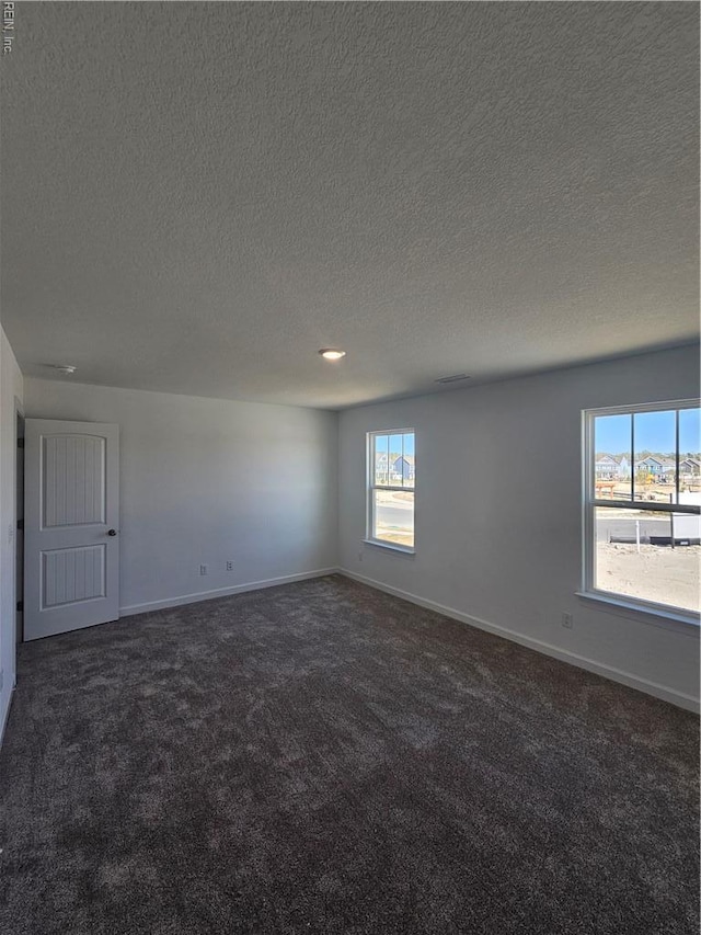 307 Iris Cir, Moyock, NC 27958 - empty room with dark carpet, a textured ceiling, and baseboards