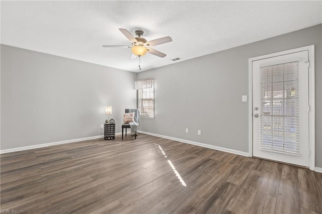 unfurnished room with ceiling fan and dark hardwood / wood-style floors