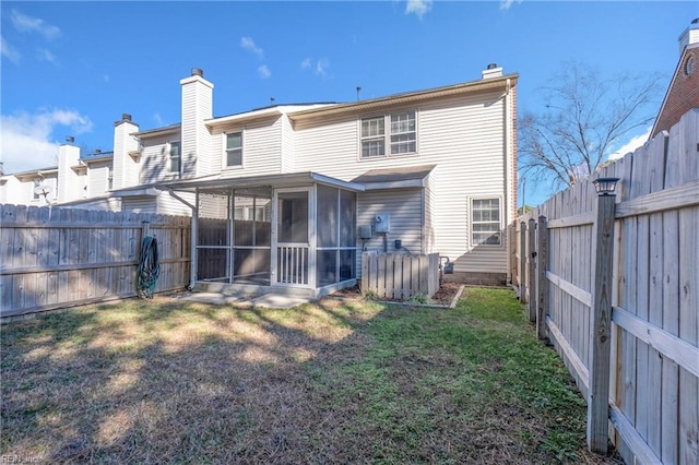 rear view of property with a yard and a sunroom