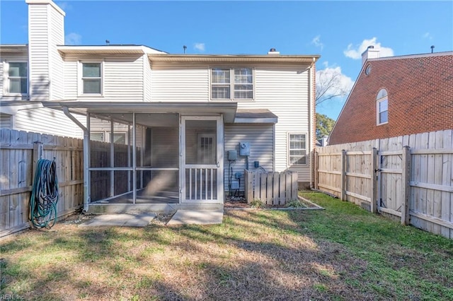 back of property featuring a sunroom and a yard