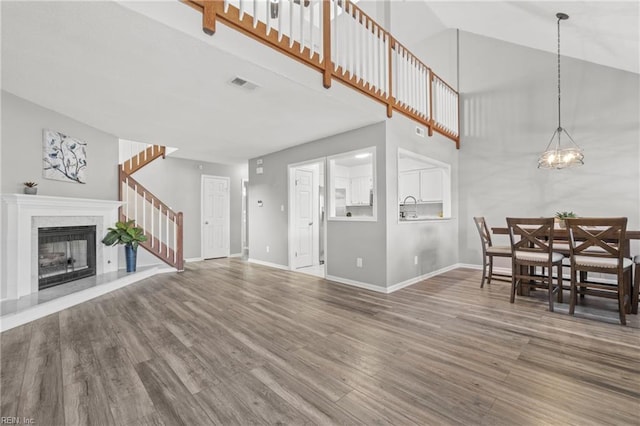 living room with an inviting chandelier, sink, and hardwood / wood-style floors