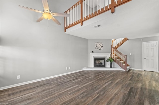 unfurnished living room with dark wood-type flooring and ceiling fan