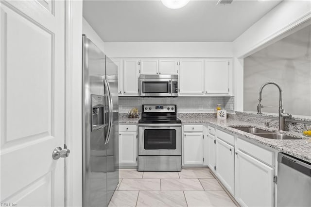 kitchen featuring appliances with stainless steel finishes, sink, and white cabinets