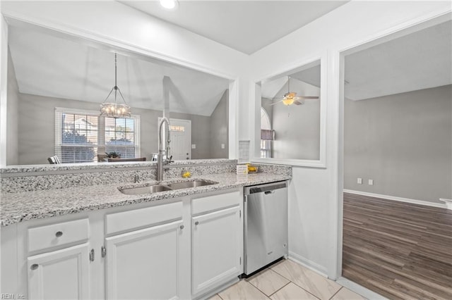 kitchen featuring white cabinetry, stainless steel dishwasher, light stone countertops, and sink