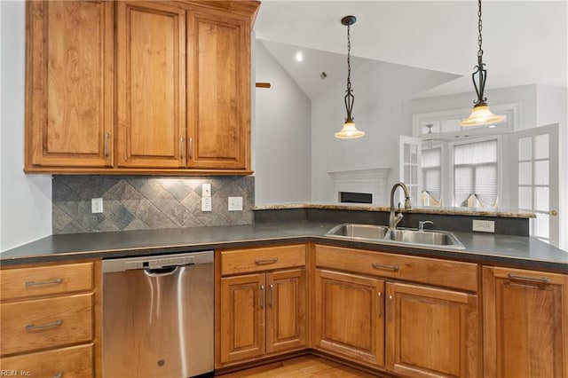 kitchen with sink, decorative light fixtures, stainless steel dishwasher, and lofted ceiling