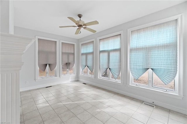 unfurnished sunroom featuring a healthy amount of sunlight and ceiling fan