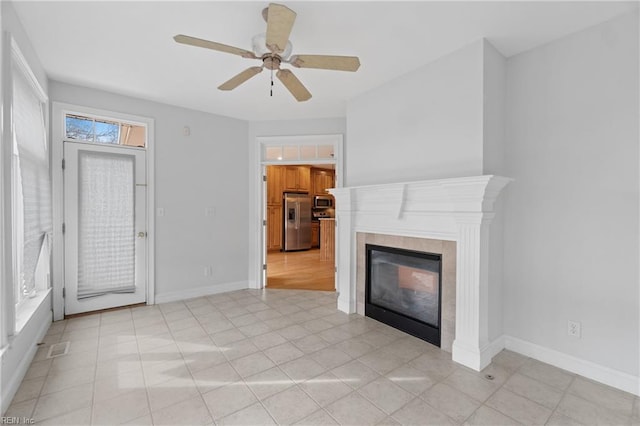 unfurnished living room with a fireplace and ceiling fan