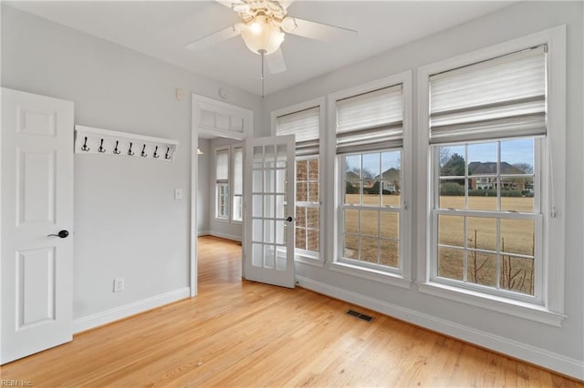 empty room with a healthy amount of sunlight, light hardwood / wood-style flooring, and ceiling fan