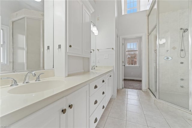 bathroom featuring a shower with shower door, vanity, and tile patterned flooring