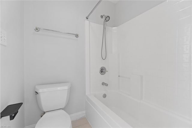 bathroom with toilet, washtub / shower combination, and tile patterned flooring