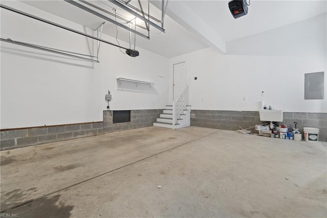 garage featuring a garage door opener, electric panel, and sink