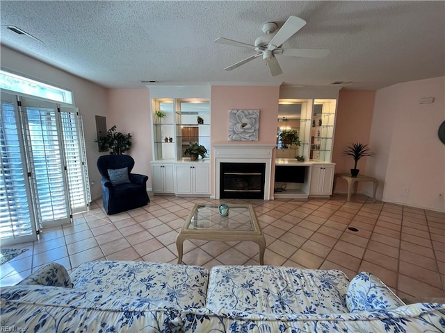 tiled living room with ceiling fan and a textured ceiling