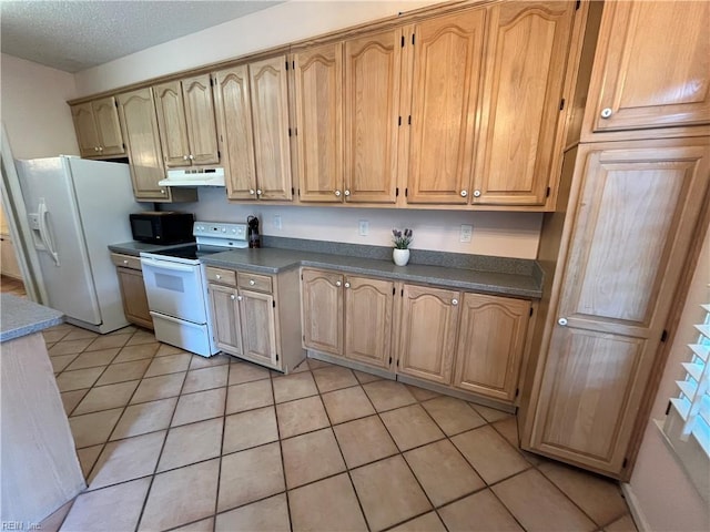 kitchen featuring white appliances, a textured ceiling, and light tile patterned floors