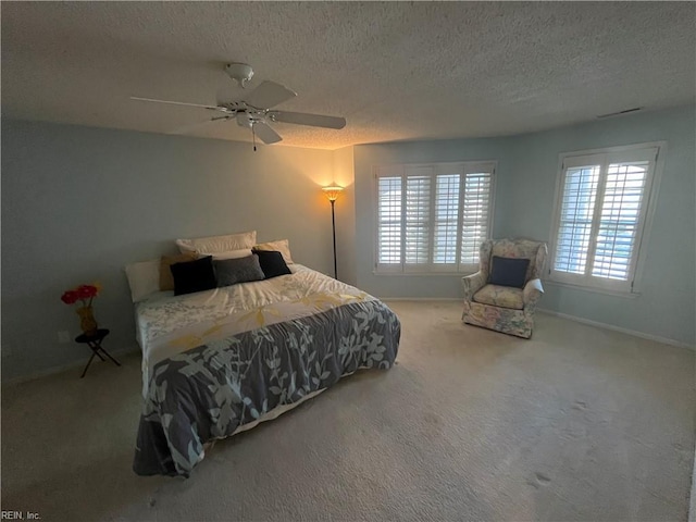 bedroom with a textured ceiling, carpet floors, and ceiling fan