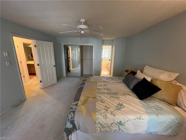 carpeted bedroom with a textured ceiling, a closet, and ceiling fan