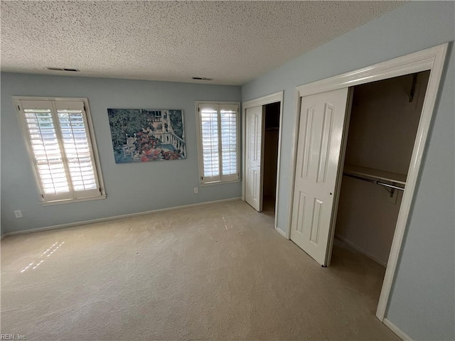 unfurnished bedroom with light carpet and a textured ceiling