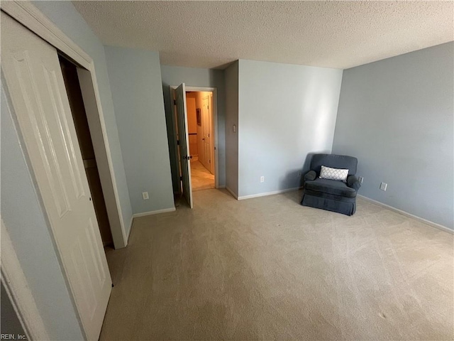 unfurnished room featuring light colored carpet and a textured ceiling