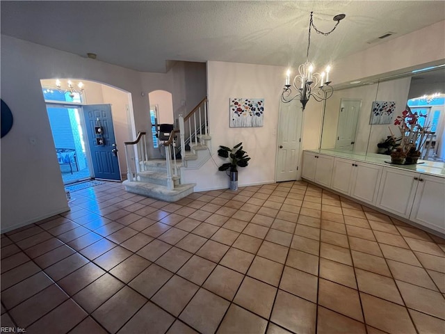 interior space with light tile patterned floors and a chandelier