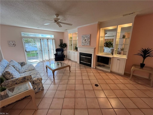 living room featuring ceiling fan, light tile patterned floors, and a textured ceiling