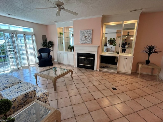 living room with ceiling fan, a textured ceiling, and light tile patterned floors